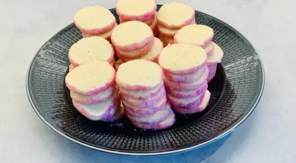 En hög med rosa och gula brysselkex på en svart tallrik. Perfekt för ett brysselkex recept!