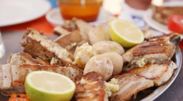 En stor tallrik med grillad fisk, potatis och citronklyftor. En härlig måltid som påminner om en marknad på Gran Canaria.