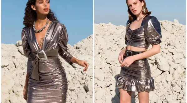Dwie modelki w metalicznych kreacjach w stylu y2k. Jedna w dopasowanej sukience z marszczeniami i szerokim paskiem, druga w crop topie i spódniczce z falbanką.