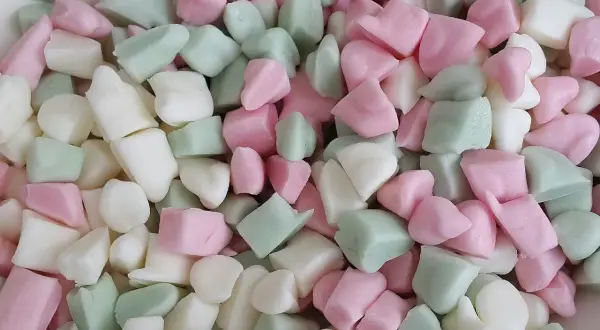 En hög med Ahlgrens bilar fluff i rosa, vitt och grönt. De ser mjuka och fluffiga ut, redo att ätas.