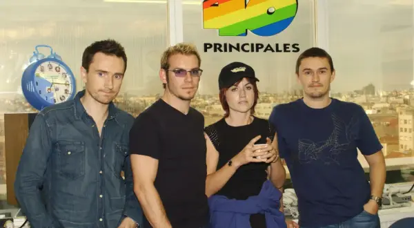 The Cranberries, marząc o sukcesie, pozują przed logo 40 Principales.