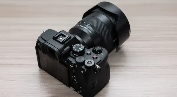 Aparat Sony a7v z obiektywem 24-105 mm G OSS na drewnianym blacie.