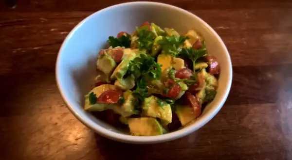 En skål med krämig pico de gallo, toppad med färsk persilja. Perfekt tillbehör!