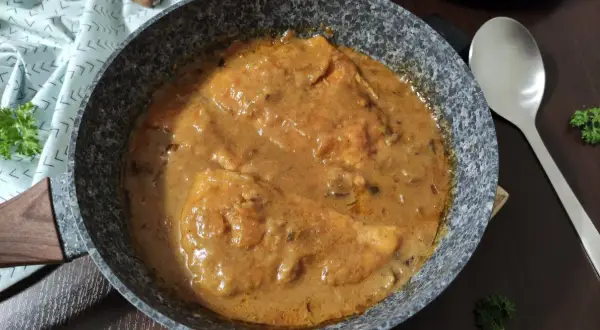 Bitki z indyka w sosie własnym, gotowe do podania. Aromatyczne danie w patelni, ozdobione natką pietruszki.