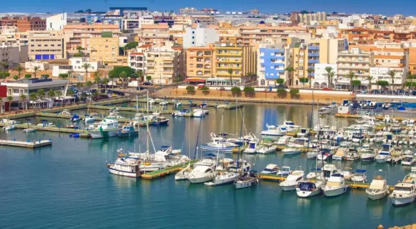 Puerto deportivo con muchos barcos y edificios de colores. Descubre qué hacer en Roquetas de Mar.