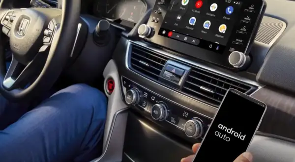 Conectar Android Auto sin cable es fácil. Un smartphone con la app muestra el sistema en la pantalla del coche.