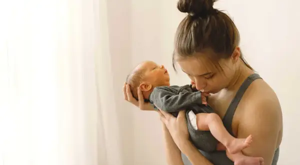 Madre abraza a su bebé recién nacido. La ternura en sus miradas hace olvidar cuánto dura la cuarentena.