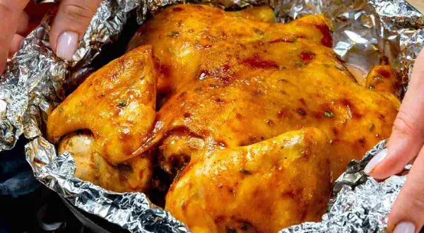 Un succulento petto di pollo dorato, cotto in carta stagnola, pronto per essere gustato.