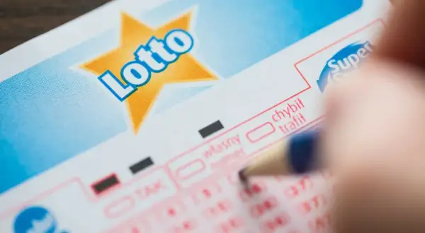 Długopis zaznacza opcję na kuponie Lotto. Zastanawiasz się, ile wynosi opłata za jeden zakład prosty w mini lotto?