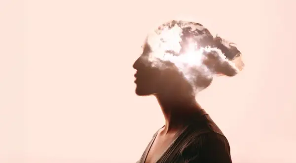 Kopfprofil einer Frau, in dem sich Wolken und Sonne spiegeln. Ein Symbol für die Weite des Denkens, die für Berufe in der Philosophie und deren Gehalt relevant ist.