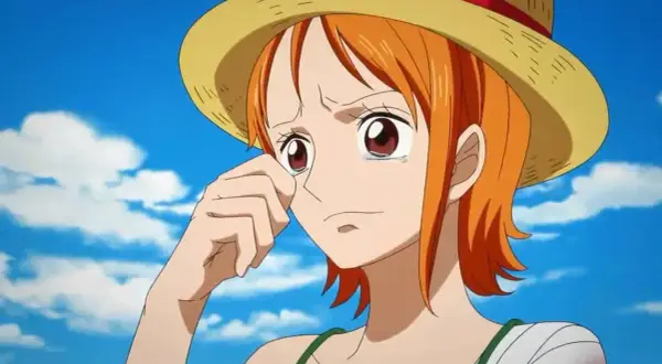 Nami One Piece weint unter ihrem Strohhut, die Hand am Auge. Ihr Arm ist bandagiert.