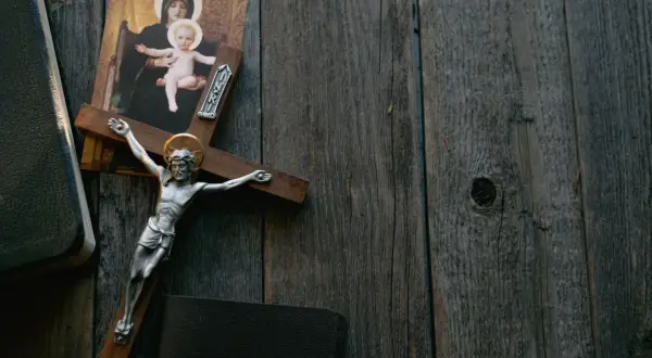 Krzyż z Jezusem, obraz Matki Boskiej i Biblia na drewnianym tle. Symbolika odkupienia i wiecznej kary za grzechy.