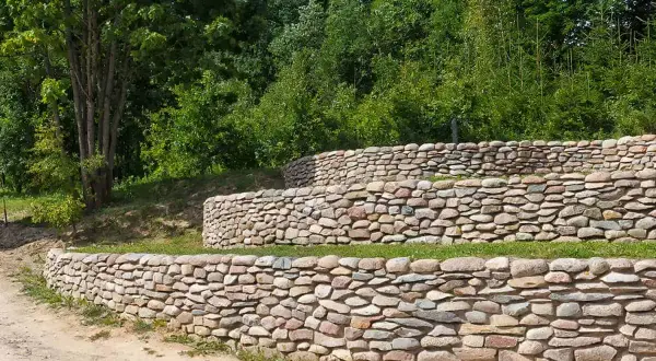 Trzy poziomy kamiennego mureu oporowego, idealny pomysł na zagospodarowanie skarpy.