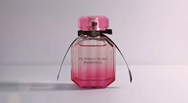 Różowa butelka kultowych perfum damskich Victoria's Secret Bombshell z czarną wstążką.