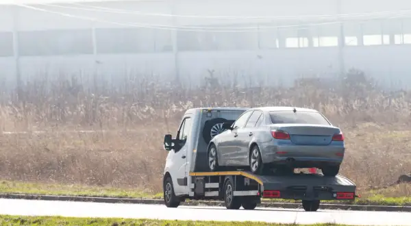 Laweta z autem na lawecie. Zastanawiasz się, ile czasu na wyrejestrowanie auta po sprzedaży?