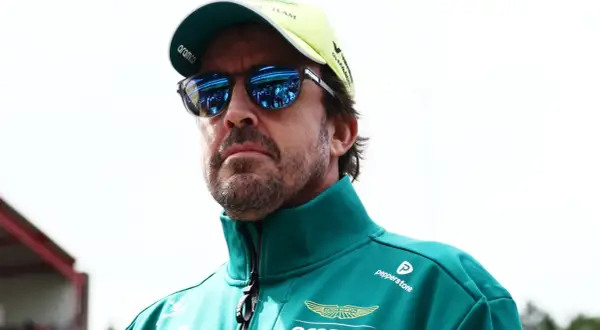 Alonso hoy, con gafas de sol reflejando el paddock, viste un polo verde de Aston Martin.