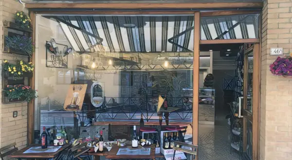 Delizie Marchigiane: prodotti tipici e street food di qualità ad Ancona. Tavolini all'esterno invitano a gustare le specialità locali.
