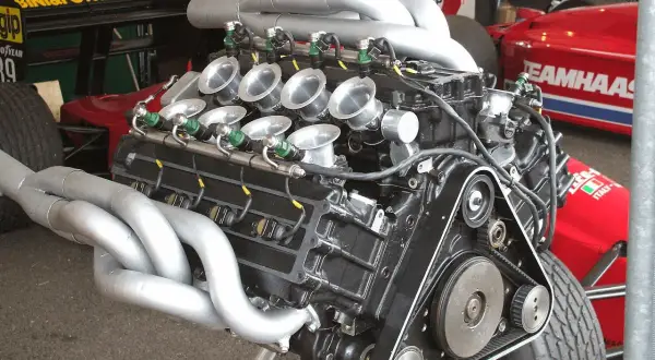 Motor V8 de F1 con colectores de escape plateados y trompetas de admisión. Un motor potente listo para la carrera.