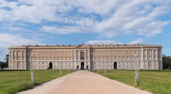 Reggia di Caserta, la piazza più grande d'Italia, con il suo imponente palazzo reale e un viale che conduce verso l'ingresso principale.