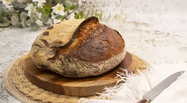 Pan artesanal de masa madre, dorado y crujiente, listo para disfrutar. El arte de hacer pan con masa madre.