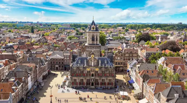 Luftaufnahme von Delft mit dem Rathaus im Zentrum. Entdecken Sie die charmanten Gassen und versteckten Plätze – echte Delft Geheimtipps.