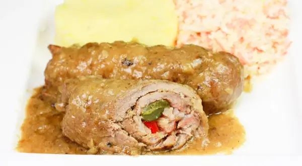 Pyszne zrazy z karkówki w sosie, podane z puree ziemniaczanym i surówką z marchewki.