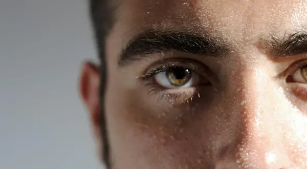Gouttes de sueur sur le front, gras, homme concentré, regard intense.