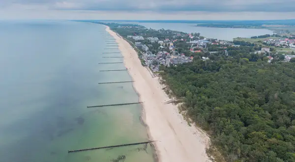 Mielno atrakcje: szeroka plaża, morze, las i zabudowania kurortu rozciągają się wzdłuż wybrzeża.