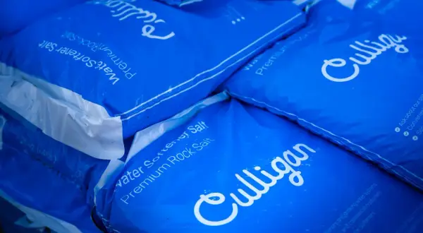 Pile de sacs bleus Culligan de sel pour adoucisseur d'eau. Difficile de dire combien de sac de sel pour adoucisseur il y a au total.
