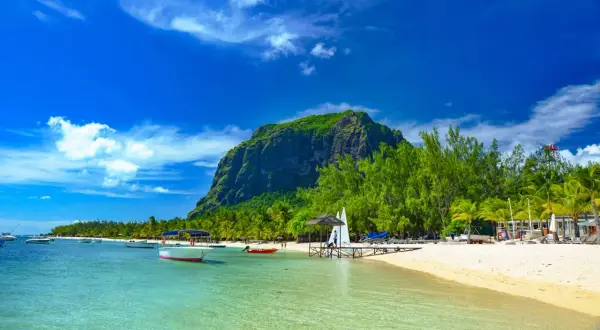 Rajska plaża na Mauritiusie z łodziami i górą Le Morne. Uważaj na silne słońce i prądy morskie.