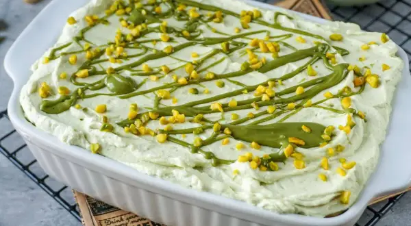 Cremiges Pistazien Tiramisu, verziert mit gehackten Pistazien und einer grünen Glasur, bereit zum Genießen.