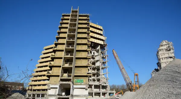 Abriss des "Affenfelsen" in Hamburg. Ein Kran demontiert das Hochhaus, daneben ein Trümmerberg.