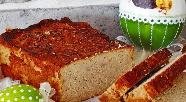 Pyszny pasztet drobiowo-wieprzowy z wątróbką, idealny na wielkanocny stół, obok ozdobnych jajek.