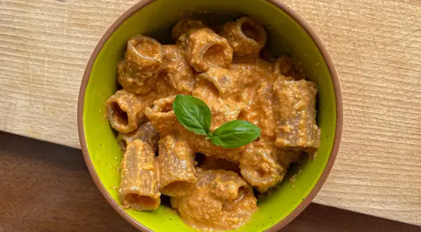 Rigatoni conditi con un cremoso pesto con mandorle, guarniti con basilico fresco.