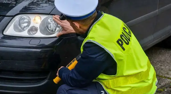 Policjant sprawdza reflektor, czy żarówki postojowe led są legalne. Lubuska Policja.