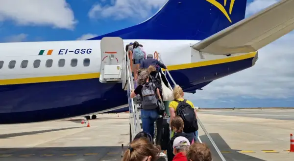 Pasażerowie wchodzą po schodkach do samolotu Ryanair. Czy to opłata transakcyjna Ryanair?