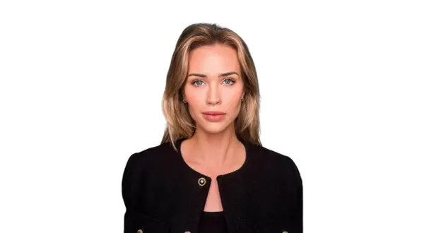 Isabella Jedler, en kvinna med blont hår och blå ögon, bär en svart kavaj med gulddetaljer.