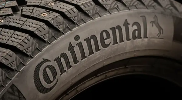 Opona zimowa z kolcami, z napisem Continental. To właśnie ta firma produkuje opony Continental, zapewniając przyczepność na lodzie.