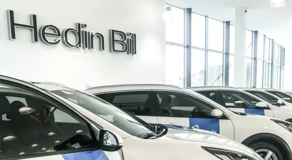 Bilar uppradade i en lokal med skylten "Hedin Bil". Kanske dags att avbryta leasingavtal hedin bil?