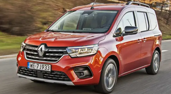 Pomarańczowy Renault Kangoo 1.5 dCi w ruchu, z widocznymi światłami LED i polskimi tablicami rejestracyjnymi WE 7J933.