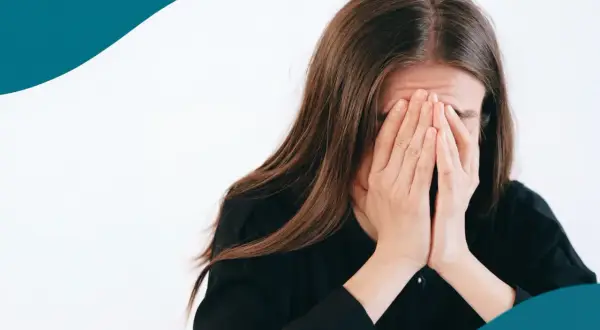 En kvinna med händerna för ansiktet, en bild som kan symbolisera stressrelaterade sjukdomar och känslan av att vara överväldigad.