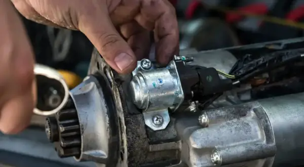 Mechanik sprawdza rozrusznik na krótko, przykręcając solenoid.