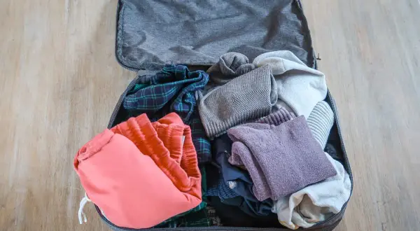 Packliste für Rucksackreisen: Kleidung wie kariertes Hemd, rote Shorts und Pullover sind wichtige Backpacking Must Haves.