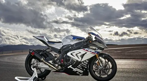 La BMW HP4 Race, una moto de competición lista para la pista, descansa bajo un cielo dramático.