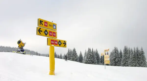 Żółte znaki na stokach narciarskich wskazują trasy: 12A, 12, 11B, 11E, 11D, 16A, 16B, 16C.