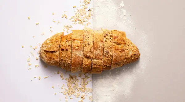 Pain de campagne tranché, parsemé de flocons d'avoine et de farine. Une idée pour par quoi remplacer la farine de seigle.