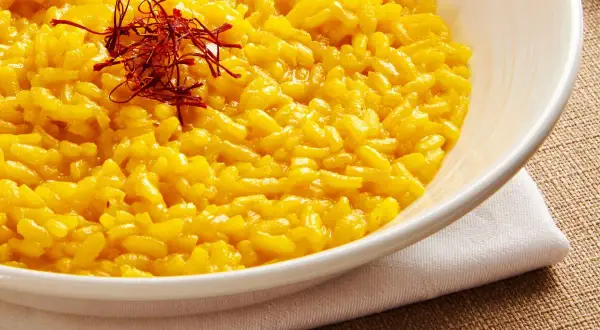 Aksamitne risotto alla milanese, złociste i aromatyczne, ozdobione nitkami szafranu.