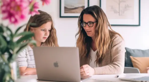 Mama uczy córkę, jak nauczyć się cierpliwości, wspólnie pracując przy laptopie.
