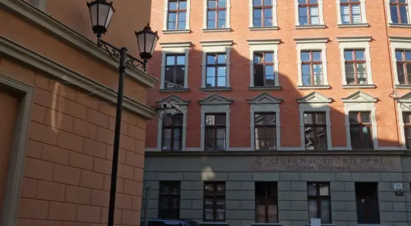 Urokliwe kamienice Gdańska z latarniami ulicznymi i ceglaną fasadą.