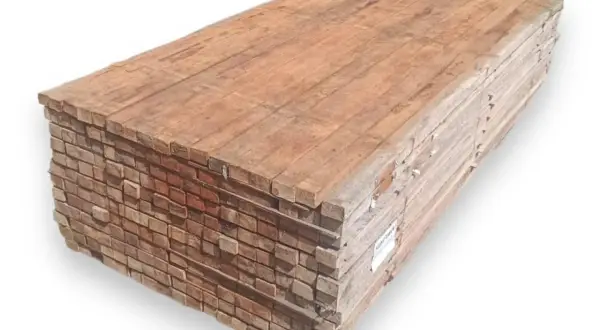 Pila de tablones de madera, mostrando la textura y el color rojizo característico de que es la madera tropical, lista para construcción.